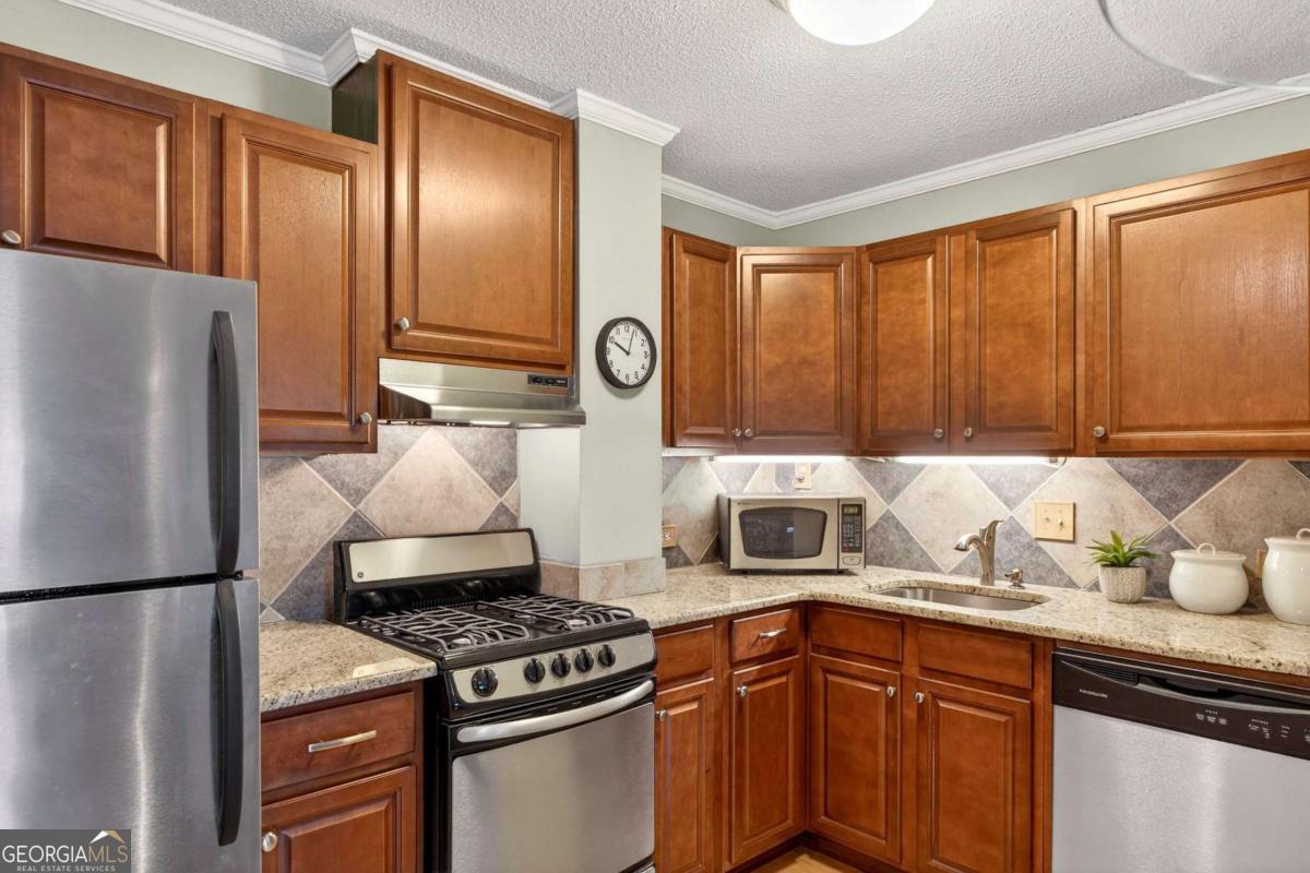 2285 Peachtree Road, Unit 1106 Atlanta, GA 30309 - Photo 5 of 27 a kitchen with a refrigerator and a sink