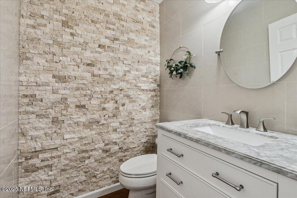 800 Marjories Way St. Augustine, FL 32092 - Photo 25 of 38 a bathroom with a granite countertop toilet sink and mirror