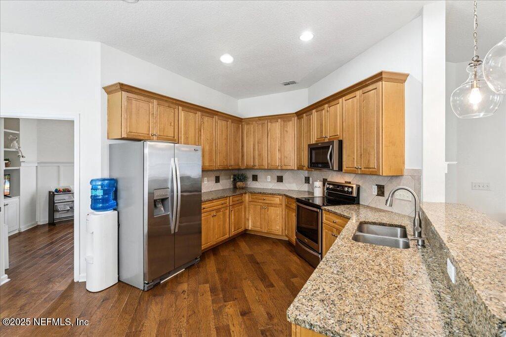 800 Marjories Way St. Augustine, FL 32092 - Photo 8 of 38 a kitchen with a refrigerator a stove top oven a sink dishwasher and wooden cabinets with wooden floor