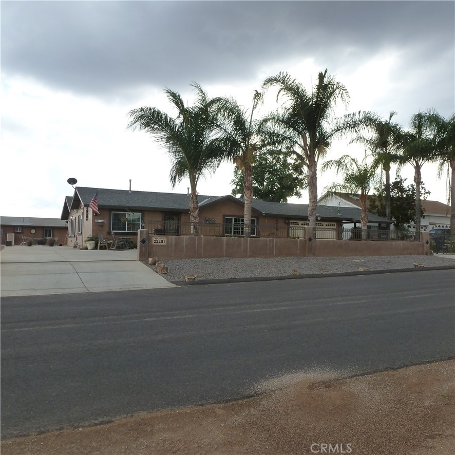 22201 Fisher Street Perris, CA 92570 - Photo 1 of 1 a front view of a house with a yard and palm trees