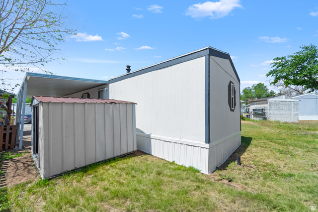 2600 North Hill Field Road, Unit 103A Layton, UT 84041 - Photo 27 of 31 White siding exterior with dark trim accents and an attached carport