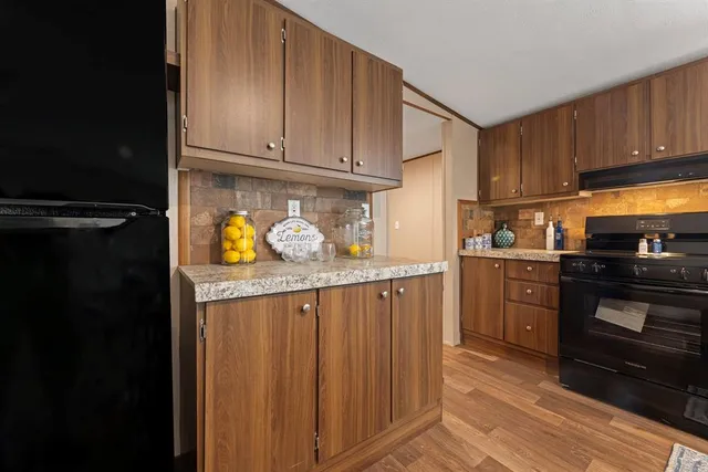 a kitchen with a refrigerator and a stove top oven