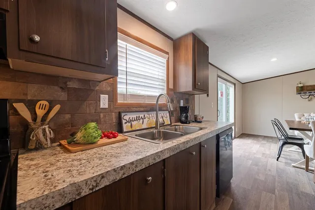 a kitchen with granite countertop sink and wooden floor
