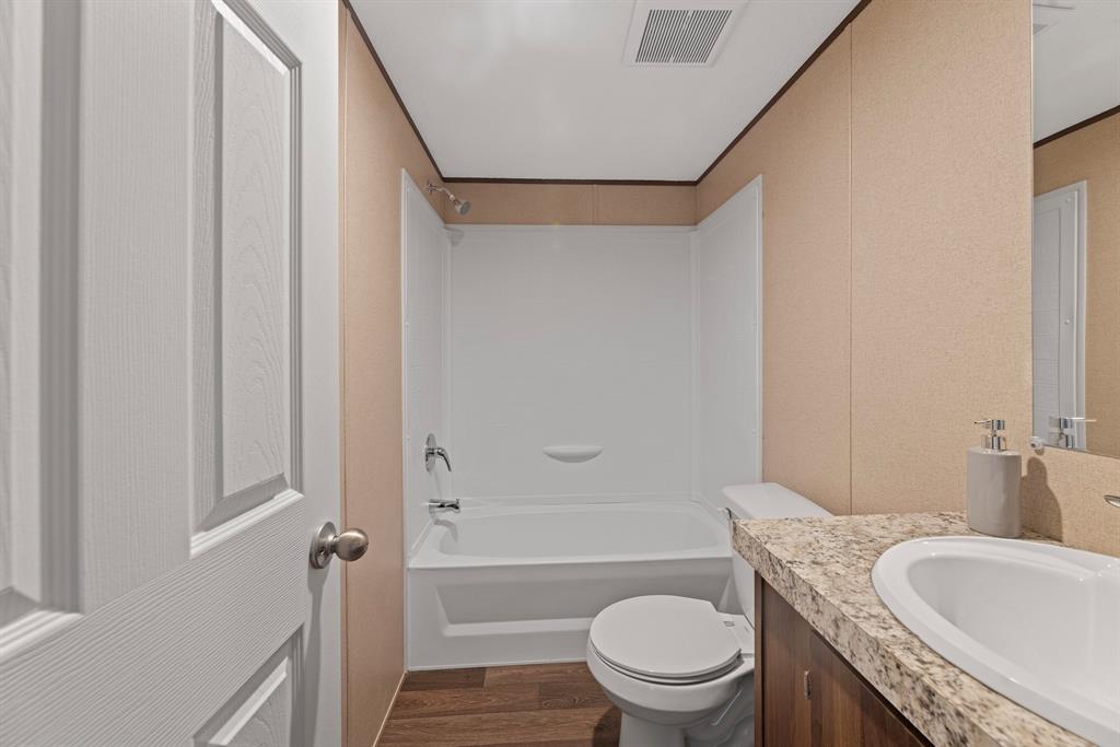 200 El Dorado Street Decatur, TX 76234 - Photo 20 of 31 a bathroom with a granite countertop toilet sink and mirror