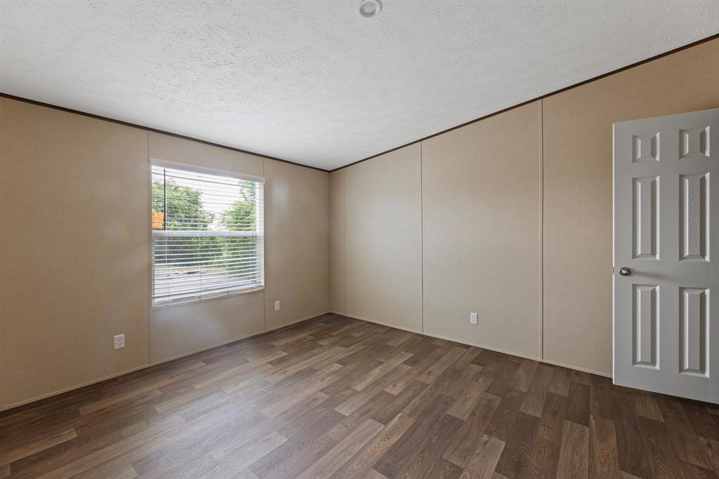200 El Dorado Street Decatur, TX 76234 - Photo 22 of 31 an empty room with wooden floor and windows