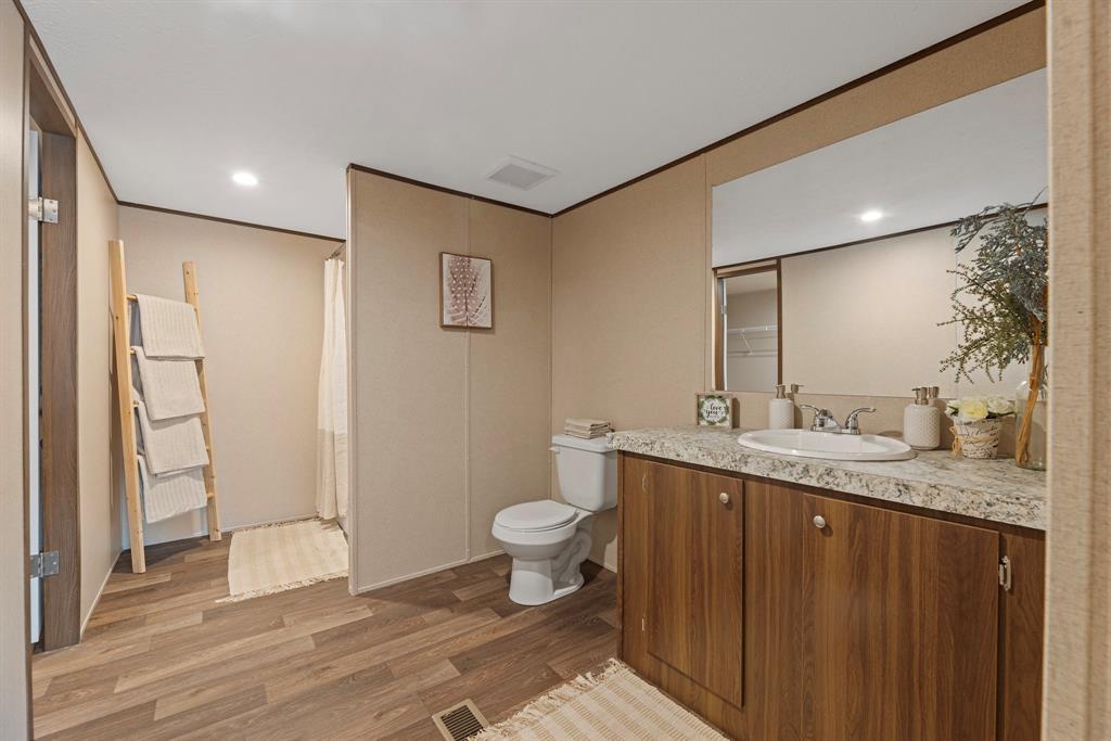 200 El Dorado Street Decatur, TX 76234 - Photo 28 of 31 a bathroom with a granite countertop sink toilet and shower