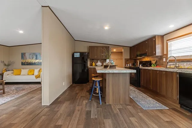 a kitchen with a sink a counter top space stainless steel appliances and cabinets