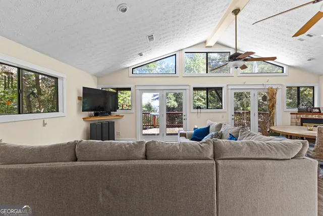 a living room with furniture kitchen and a chandelier