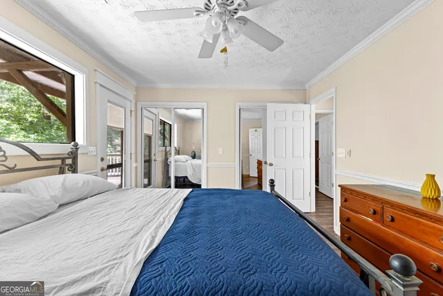a bedroom with a bed table closet and a window