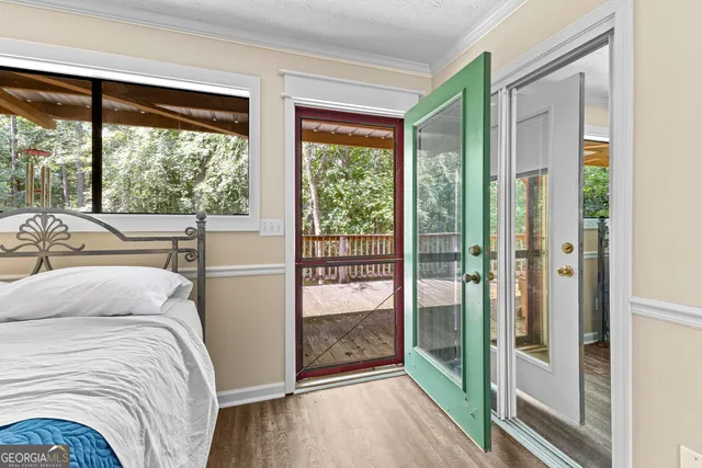 a bedroom with a bed wooden floor and window