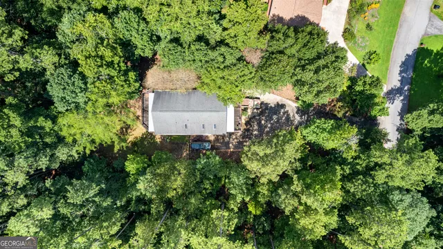 an aerial view of residential house with outdoor space and trees all around