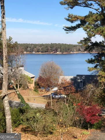 an aerial view of residential house with outdoor space and trees all around