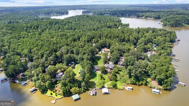 an aerial view of a house with a yard and lake view