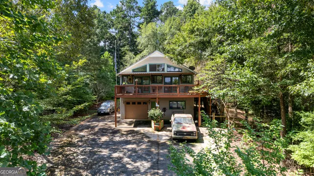 a view of a tall house with a small yard and large trees