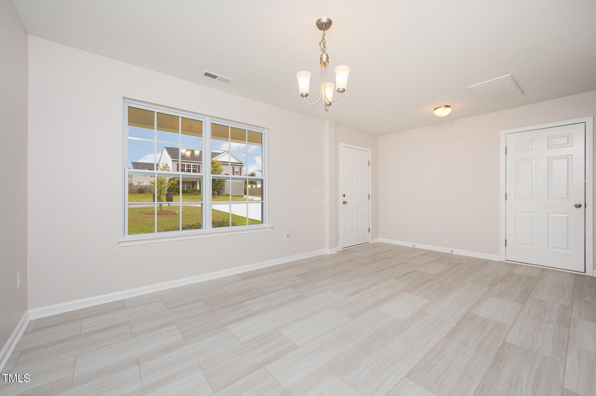 356 Botanical Court Bunnlevel, NC 28323 - Photo 11 of 31 a view of an empty room with a window and wooden floor