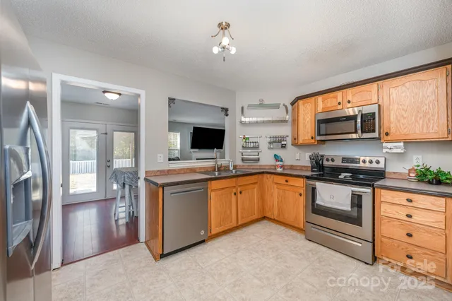 a kitchen with stainless steel appliances granite countertop a stove top oven microwave and a refrigerator