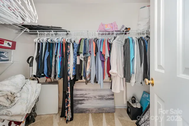 a view of walk in closet with clothes