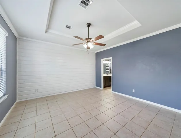 a view of an empty room with window and chandelier fan