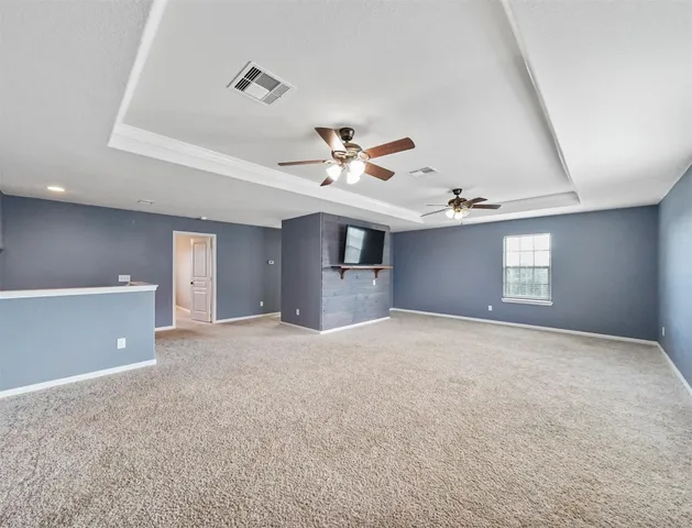 a view of an empty room with a ceiling fan