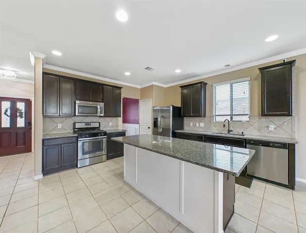 a large kitchen with granite countertop lots of counter space and window
