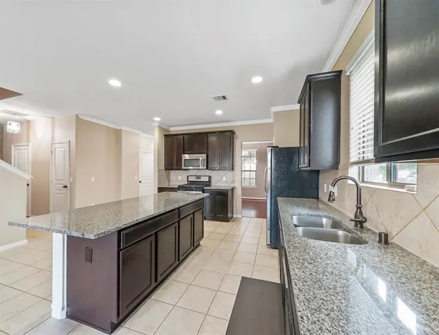 a large kitchen with stainless steel appliances kitchen island granite countertop a large counter top and wooden floors