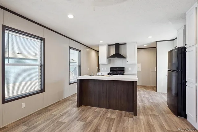 a kitchen with stainless steel appliances a refrigerator and wooden floor