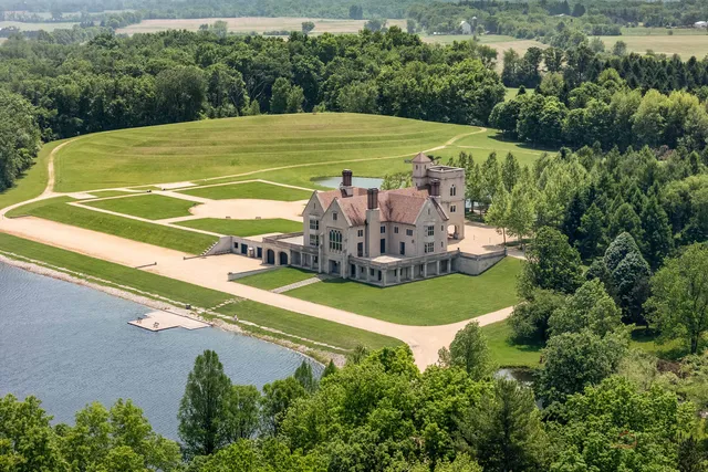 a view of a tennis ground with a large trees
