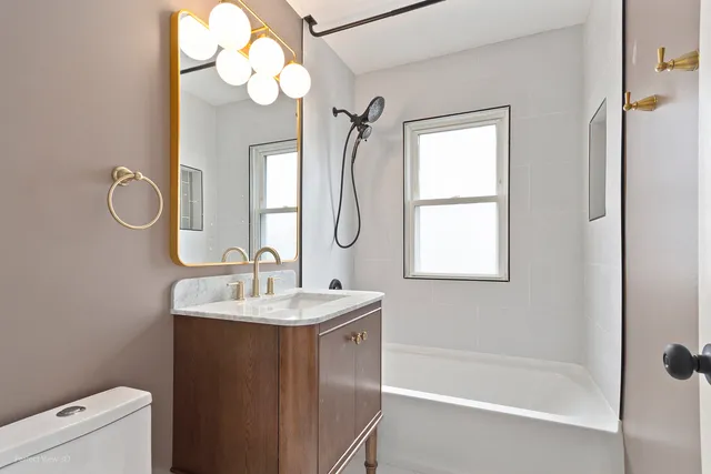 a bathroom with a sink mirror and a bathtub