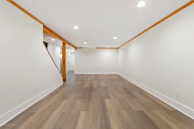 a view of empty room with wooden floor