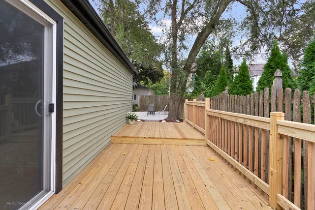a view of balcony with wooden floor and fence and a barbeque