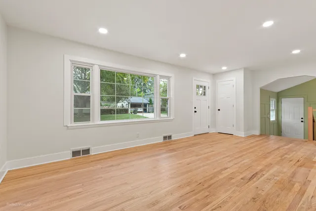 a big room with wooden floor and windows