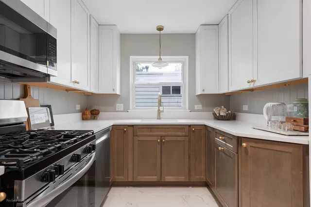 a kitchen with stainless steel appliances granite countertop a sink stove top oven and cabinets