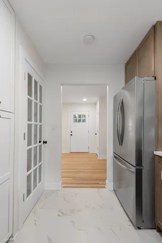 a view of kitchen with cabinets and refrigerator