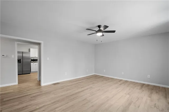 a view of a room with wooden floor and a ceiling fan