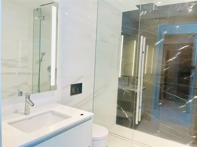 a bathroom with a sink a toilet and shower