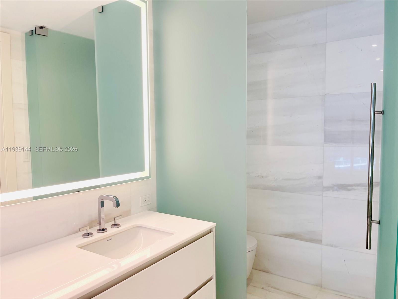 300 Biscayne Blvd Way, Unit 2807 Miami, FL 33131 - Photo 51 of 59 a bathroom with a sink and a mirror