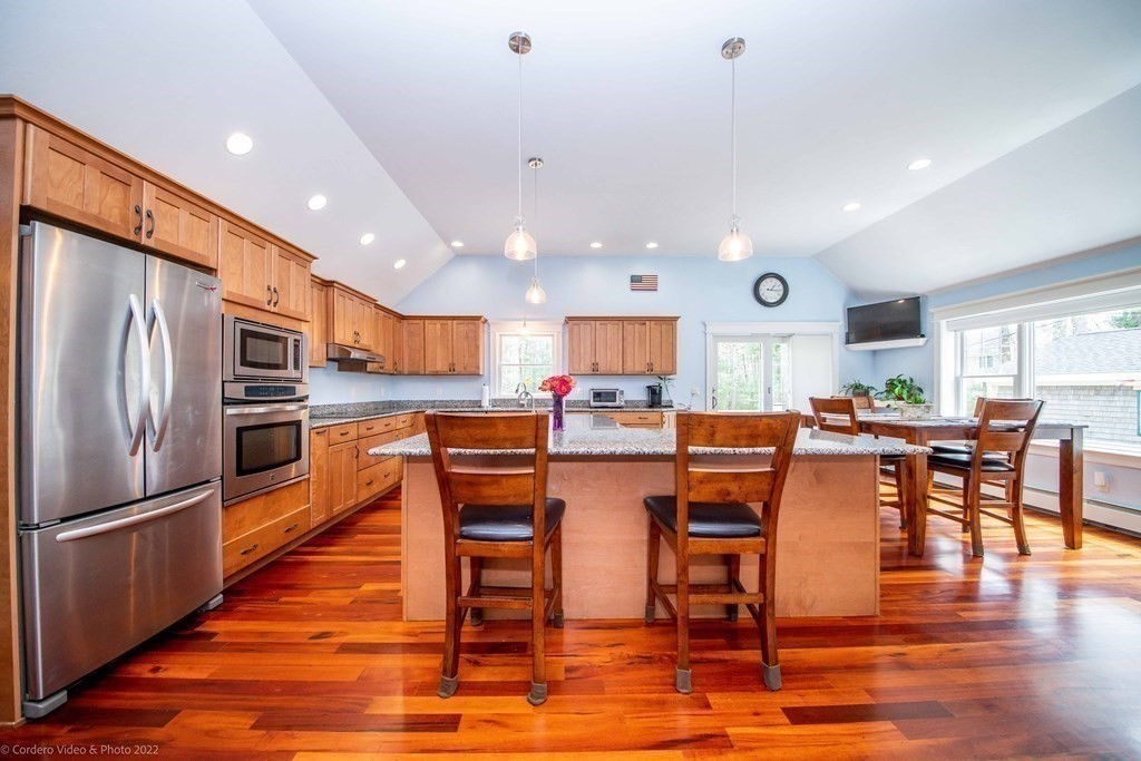 558 County Road Wareham, MA 02576 - Photo 13 of 32 a kitchen with stainless steel appliances granite countertop a refrigerator a stove top oven and a dining table with wooden floor