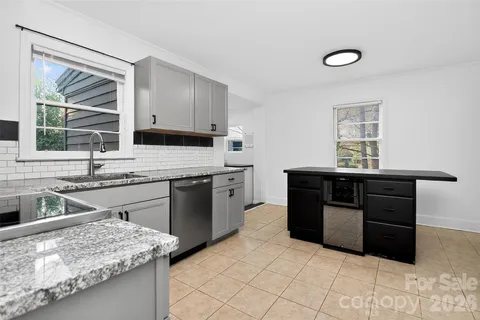 a kitchen with granite countertop a sink stove and cabinets
