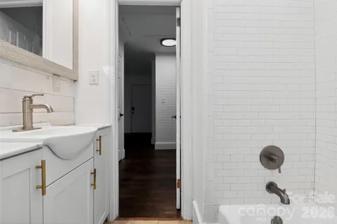 an empty room with wooden floor cabinet and windows