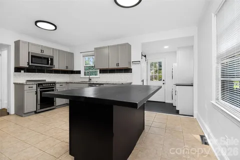 a kitchen with kitchen island a stove a sink and a refrigerator