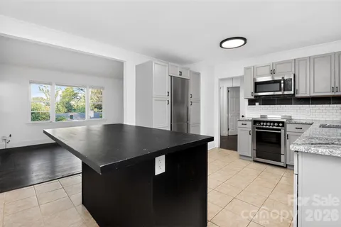 a kitchen with stainless steel appliances granite countertop a refrigerator sink and stove