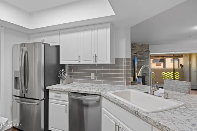 a kitchen with stainless steel appliances granite countertop a refrigerator and a sink