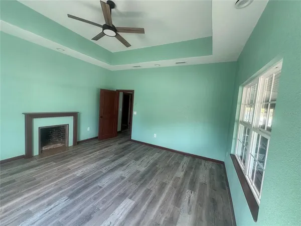 a view of an empty room with glass door and wooden floor