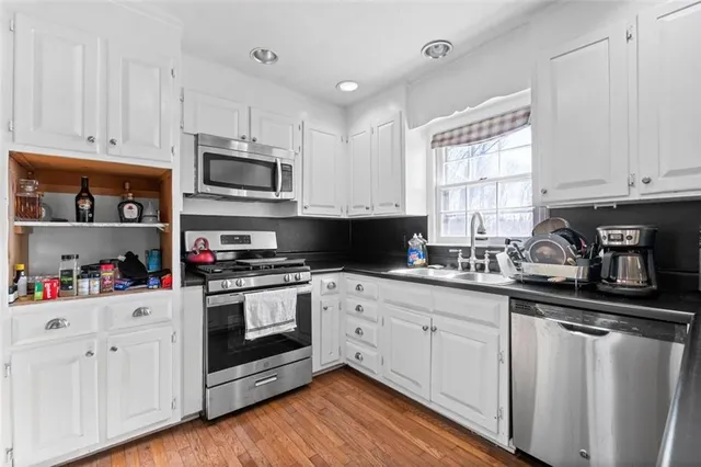 a kitchen with cabinets appliances a sink and a window