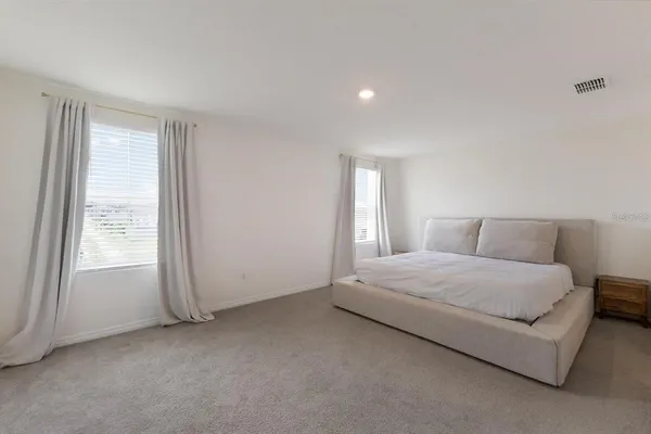 a spacious bedroom with a bed and a window