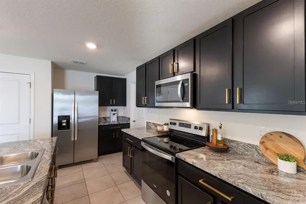 a kitchen with granite countertop stainless steel appliances and wooden cabinets