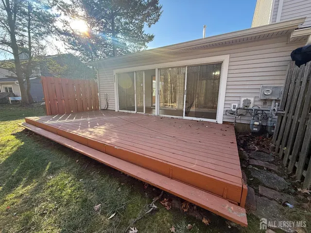 a view of a backyard with chairs and wooden fence