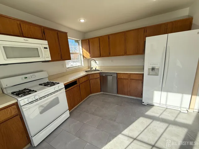 a kitchen with stainless steel appliances granite countertop a stove a sink and a refrigerator