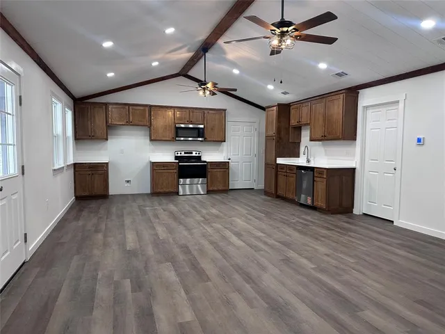 a large kitchen with stainless steel appliances kitchen island a large counter space a sink and appliances