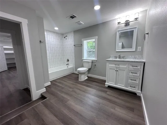 a bathroom with a double vanity sink a toilet and a mirror